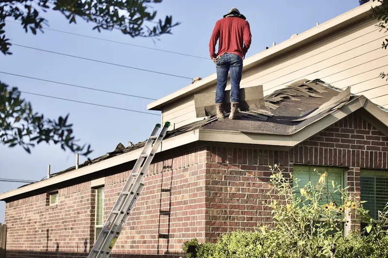 Professional roofer working on a residential roof in Melrose